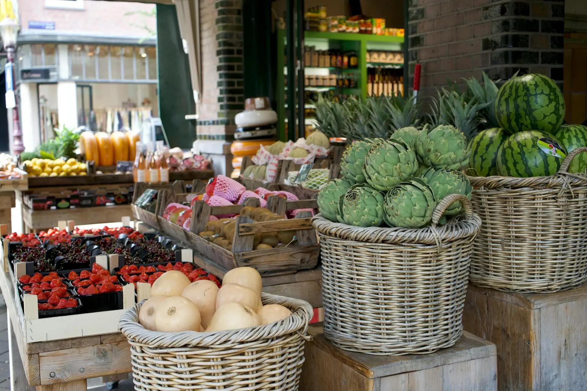 Marché en plein air avec des étals de fruits et légumes colorés, avec des clients en arrière-plan.